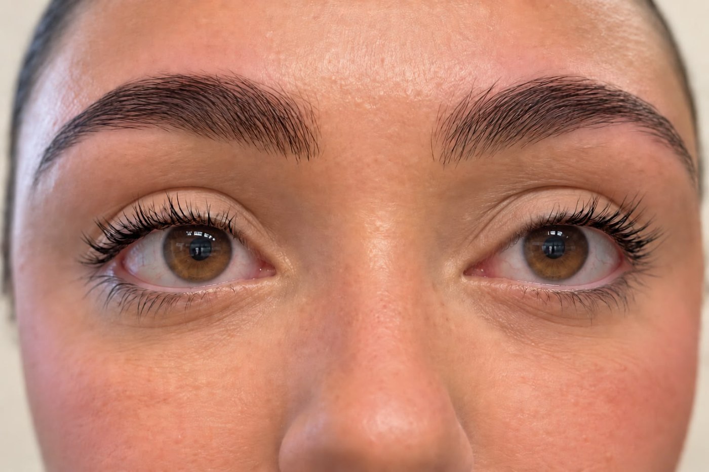 Nahaufnahme der Augenpartie mit dunkel gefärbten Wimpern und Augenbrauen